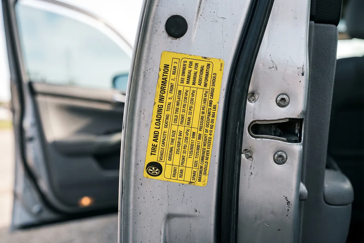 Tire information placard on a car door jamb